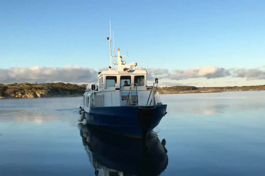 M/S Kosterskär i spegelblankt vatten inför hamnläggning i hamnen.