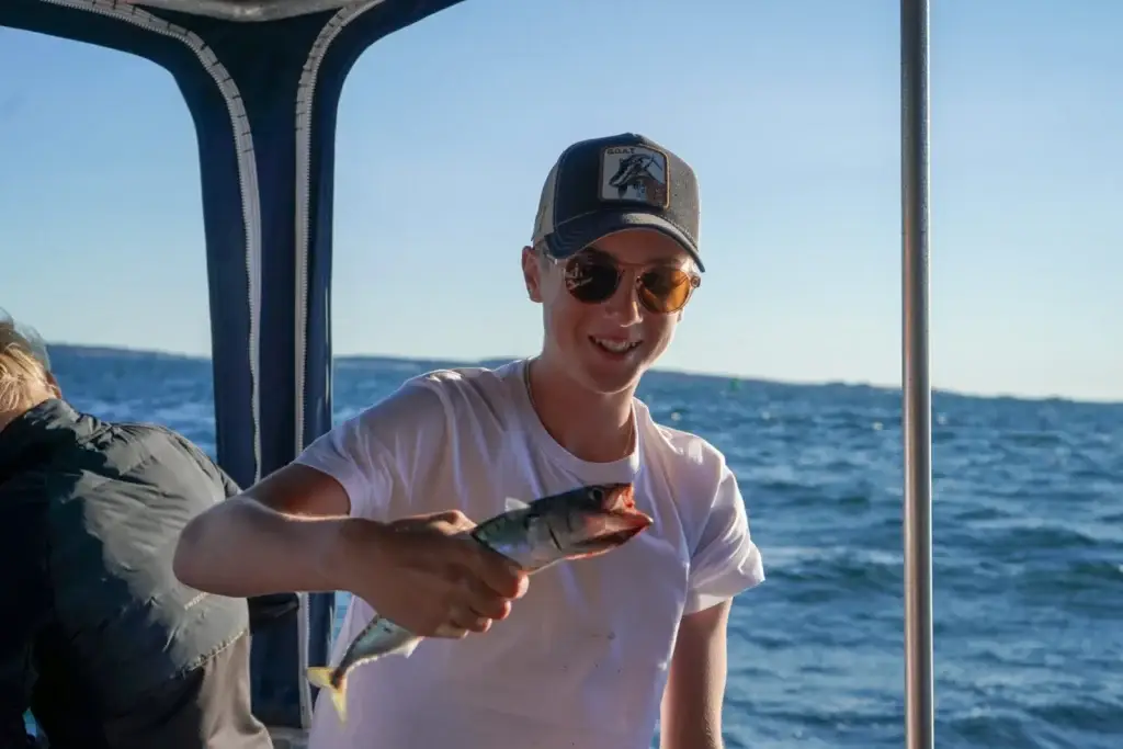 Pojke på havsfiske från båt i Kosteröarna