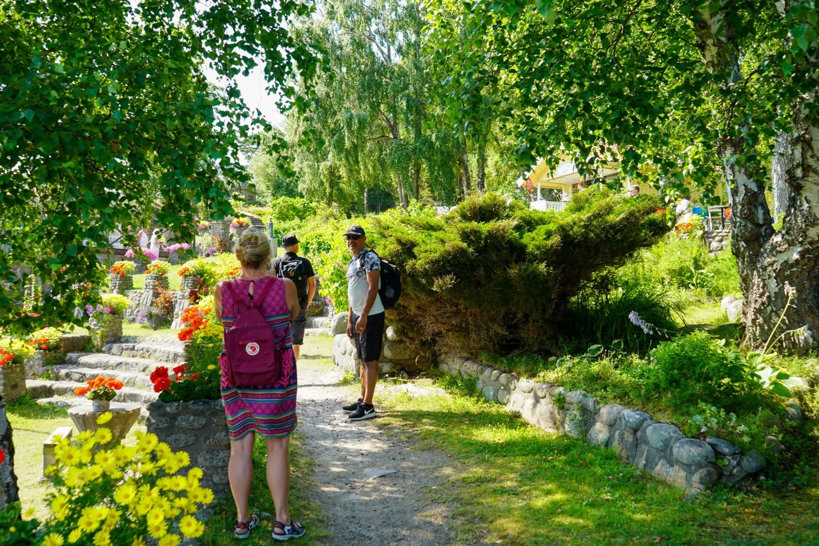 Stigen in i Alaskaträdgården under träden intill