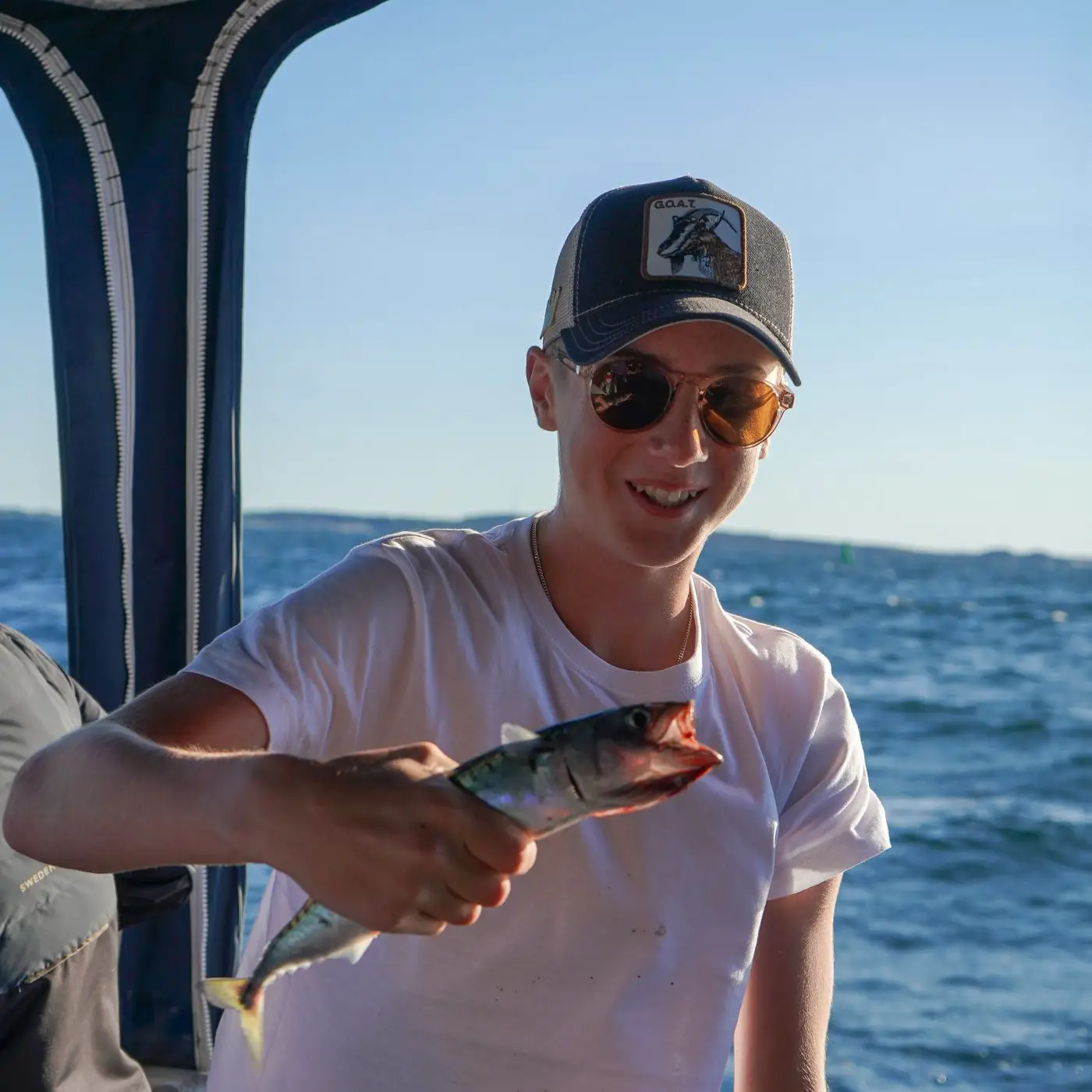 Pojke på havsfiske från båt i Kosteröarna